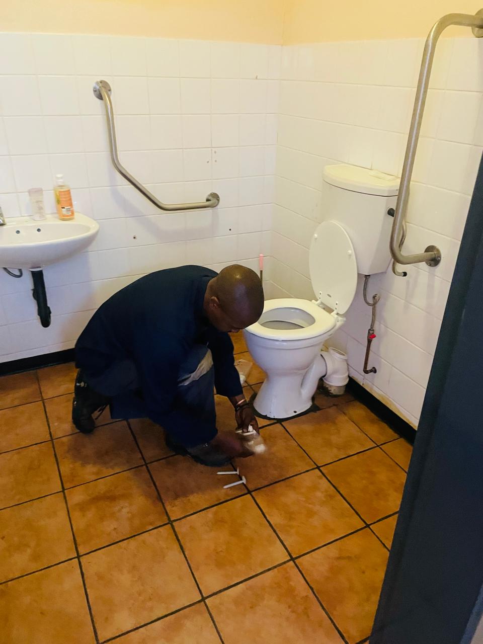 Worker carrying out washroom maintenance